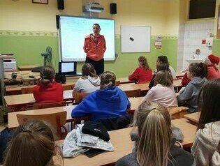 Pan Przemek udziele prelekcji uczniom w sali.