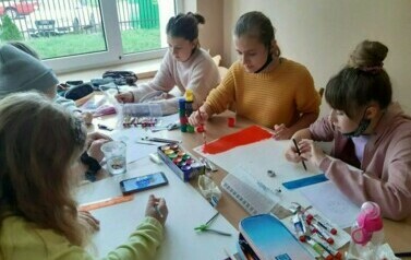 Uczniowie w sali wykonują flagę Włoch.